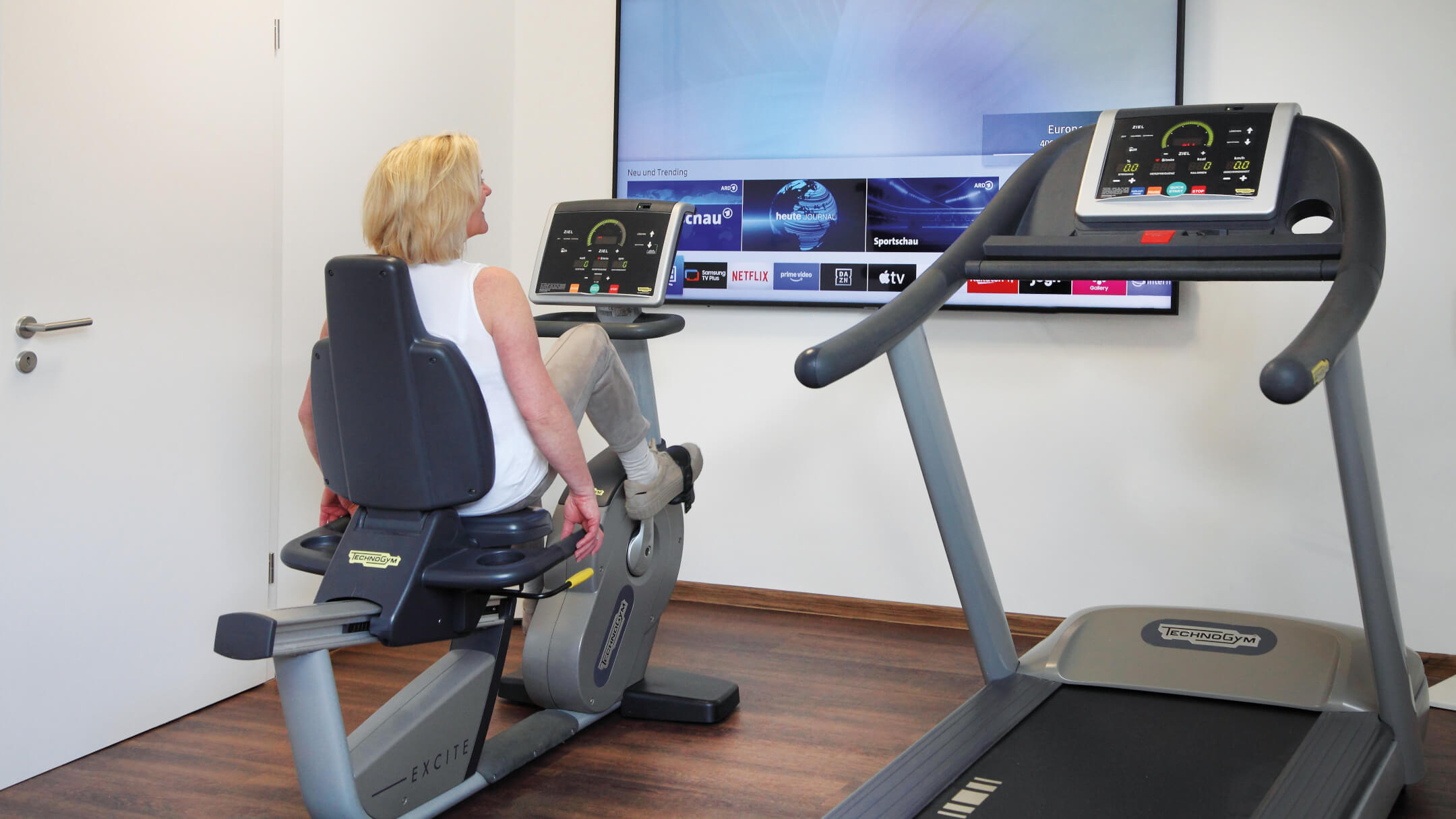 Eine Frau sitzt auf einem Ergometer